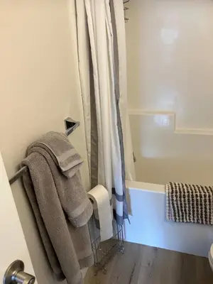 a bathroom with towels hanging on a door at Welcome to the Cozy Studio in Kelowna