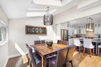 a kitchen and dining room with a wooden table and chairs at Family-Friendly 3BR Home in Vancouver