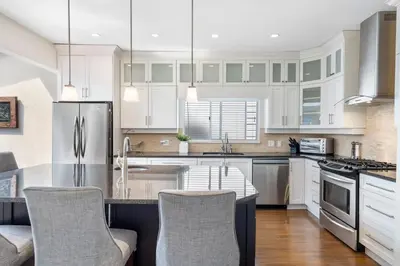 a kitchen with white cabinets and stainless steel appliances at Family-Friendly 3BR Home in Vancouver