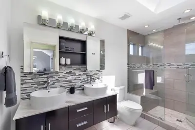 a bathroom with two sinks and a toilet and a shower at Family-Friendly 3BR Home in Vancouver