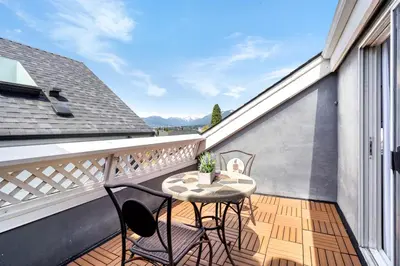 a patio with a table and chairs on a balcony at Family-Friendly 3BR Home in Vancouver