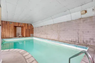 a swimming pool with blue water in a building at Spacious Home with Indoor Pool in Vancouver