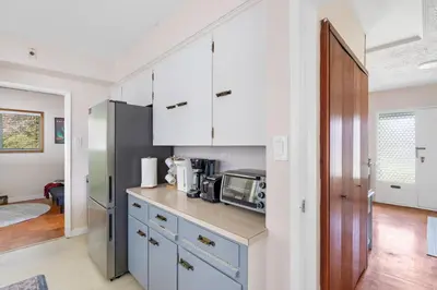 a kitchen with white cabinets and a microwave at Spacious Home with Indoor Pool in Vancouver
