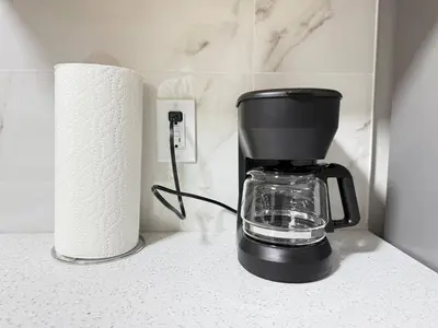 a coffee maker sitting on a counter next to a roll of paper towels at Range View Retreat/2BR Suite in Calgary