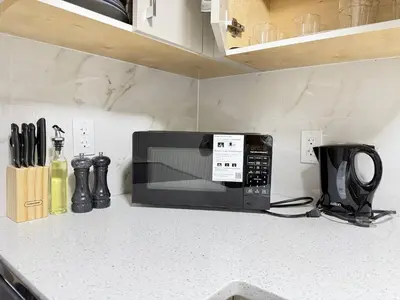 a microwave sitting on a counter in a kitchen at Range View Retreat/2BR Suite in Calgary