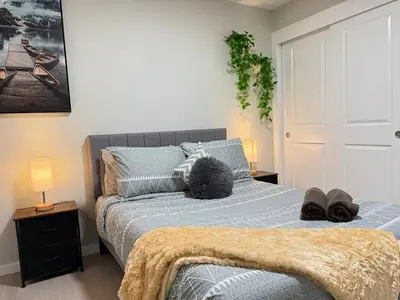 a bedroom with a bed with two pairs of shoes on it at Range View Retreat/2BR Suite in Calgary