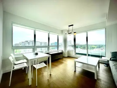 a living room with a table and chairs and windows at Central Stylish 3B2B near Richmond Center in Richmond