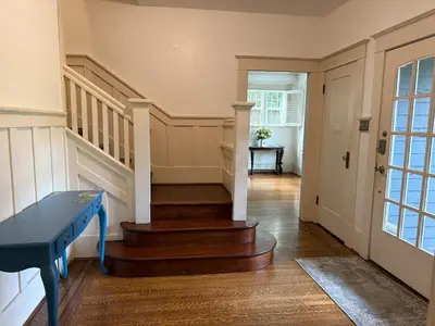a hallway with stairs and a blue table in a house at Spacious Villa 6BR 3 BA - Free Parking - Near Kitsilano Beach & Attractions - 15' to DT in Vancouver