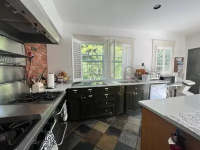 a kitchen with black cabinets and a stove top oven at Spacious Villa 6BR 3 BA - Free Parking - Near Kitsilano Beach & Attractions - 15' to DT in Vancouver