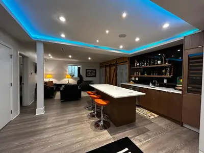 a kitchen with a bar and a living room at Edge of the Mountain Villa in North Vancouver