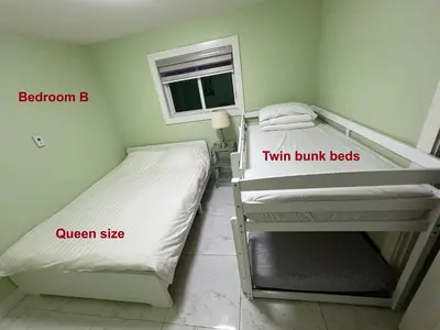 a small room with two bunk beds and a window at Newton Suite in Surrey