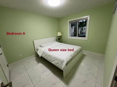 a bedroom with a queen size bed and a window at Newton Suite in Surrey
