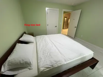 a bedroom with a large bed with white sheets and pillows at Newton Suite in Surrey