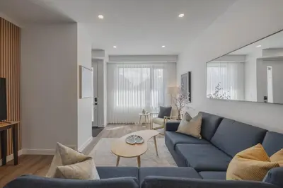 a living room with a blue couch and a table at Fenced Yard, Free Parking, 2 King Beds with AC in Calgary