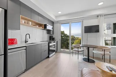 a kitchen with a table and a dining room at Brand new suite downtown Kelowna - walk everywhere! in Kelowna