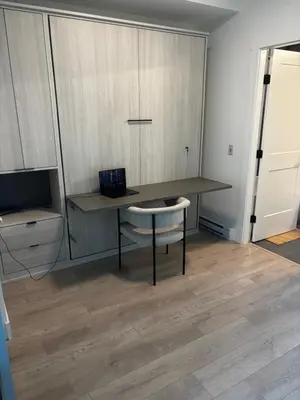 a room with a desk and a chair and a television at Brand new suite downtown Kelowna - walk everywhere! in Kelowna