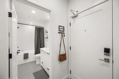 a white bathroom with a toilet and a shower at Chic Condo with Stylish Amenities in White Rock in Surrey