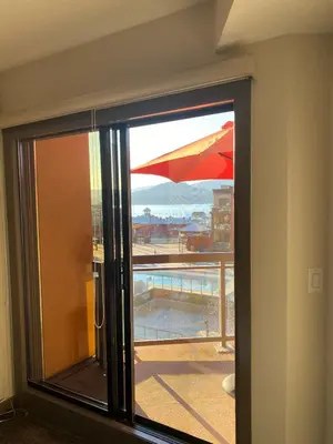 a window with a view of a pool and an umbrella at PlayadelSol in Kelowna