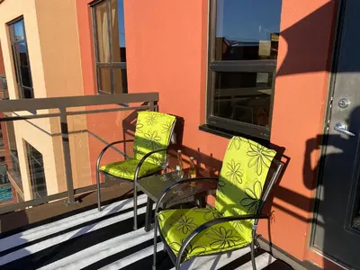 two chairs and a glass table on a balcony at PlayadelSol in Kelowna