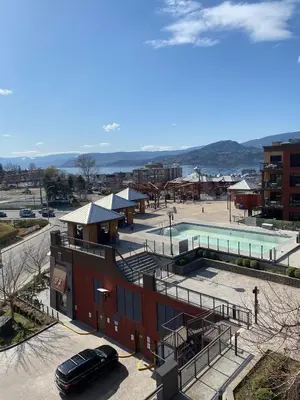 a building with a pool and a parking lot at PlayadelSol in Kelowna