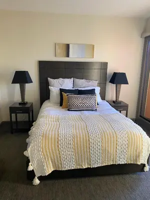 a bedroom with a large bed with two lamps at PlayadelSol in Kelowna