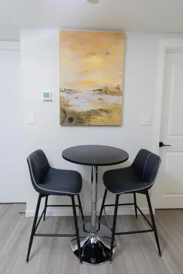 a table and two chairs in a room with a painting at Cozy Quarters Your Comfy Haven in Calgary