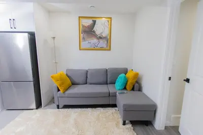 a living room with a couch and a stool at Cozy Quarters Your Comfy Haven in Calgary