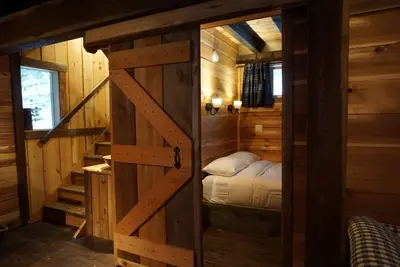 a bed in a room with a wooden door at Logden Lodge in Nelson