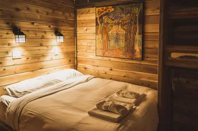 a bedroom with a bed in a wooden room at Logden Lodge in Nelson