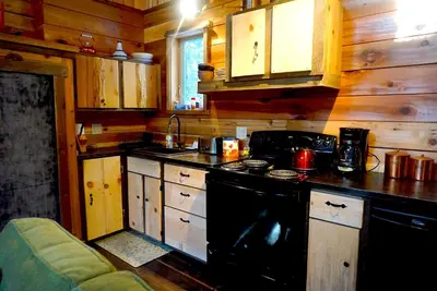 a kitchen with a black stove and a sink at Logden Lodge in Nelson