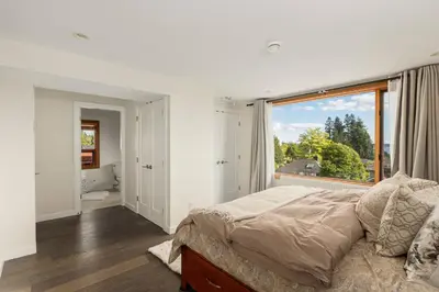 a bedroom with a bed and a large window at Quiet Modern Dundadrave Oasis in West Vancouver