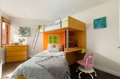 a small bedroom with a bunk bed and a pink chair at Quiet Modern Dundadrave Oasis in West Vancouver