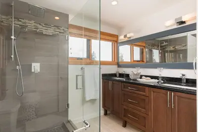 a bathroom with a glass shower and a sink at Quiet Modern Dundadrave Oasis in West Vancouver