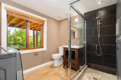 a bathroom with a shower and a toilet and a sink at Quiet Modern Dundadrave Oasis in West Vancouver