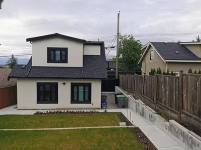 a white house with a fence in a yard at Modern Private 3BR House in Vancouver