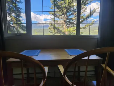 a wooden table with two chairs in front of a window at Alpenrose 204 Hottubs, Mountains View, KING bed in Golden
