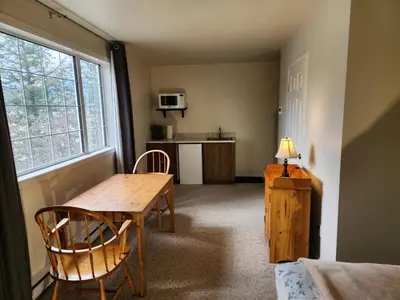 a room with a table and chairs and a kitchen at Alpenrose 204 Hottubs, Mountains View, KING bed in Golden