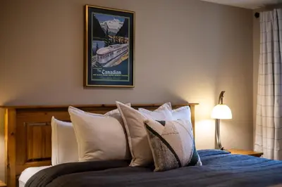 a bedroom with a bed with blue sheets and pillows at Timberline - Spruce Lodge by Fernie Central Reservations in Fernie