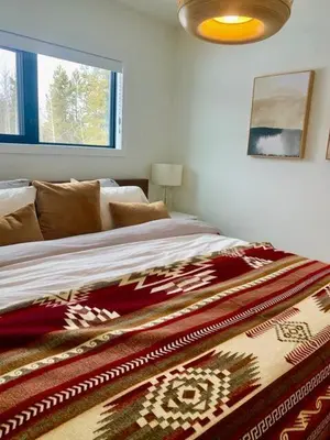 a bed with a blanket on it in a bedroom at The White House in Golden