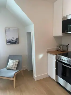 a kitchen with a chair and a table and a stove at The White House in Golden