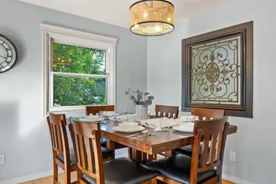 a dining room with a table and chairs and a window at Nineteen55 4BR Parkside Home in Central Red Deer in Red Deer