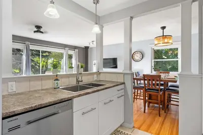 a kitchen with a sink and a dining room at Nineteen55 4BR Parkside Home in Central Red Deer in Red Deer