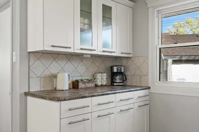 a kitchen with white cabinets and a counter top at Nineteen55 4BR Parkside Home in Central Red Deer in Red Deer