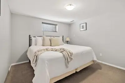 a white bedroom with a large white bed with pillows at Nineteen55 4BR Parkside Home in Central Red Deer in Red Deer