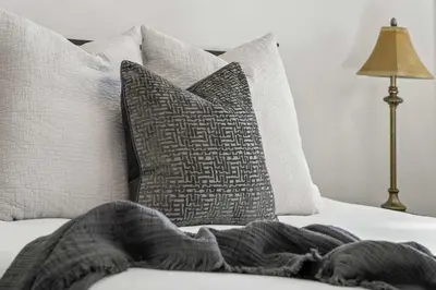 a bed with pillows and a blanket on it at Nineteen55 4BR Parkside Home in Central Red Deer in Red Deer