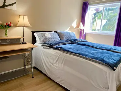 a bedroom with a bed and a desk and a window at Urban Retreat in Nanaimo