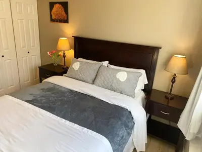 a bedroom with a large bed with two lamps and two tables at Urban Retreat in Nanaimo