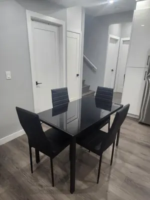 a black dining room table and chairs in a room at Home in Northwest Calgary in Calgary