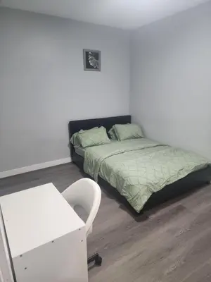a bedroom with a bed and a desk and a chair at Home in Northwest Calgary in Calgary