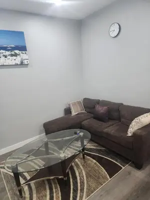 a living room with a brown couch and a glass table at Home in Northwest Calgary in Calgary